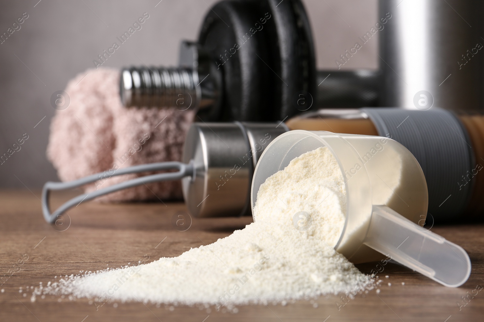 Photo of Composition with measuring scoop of protein powder on wooden table, closeup