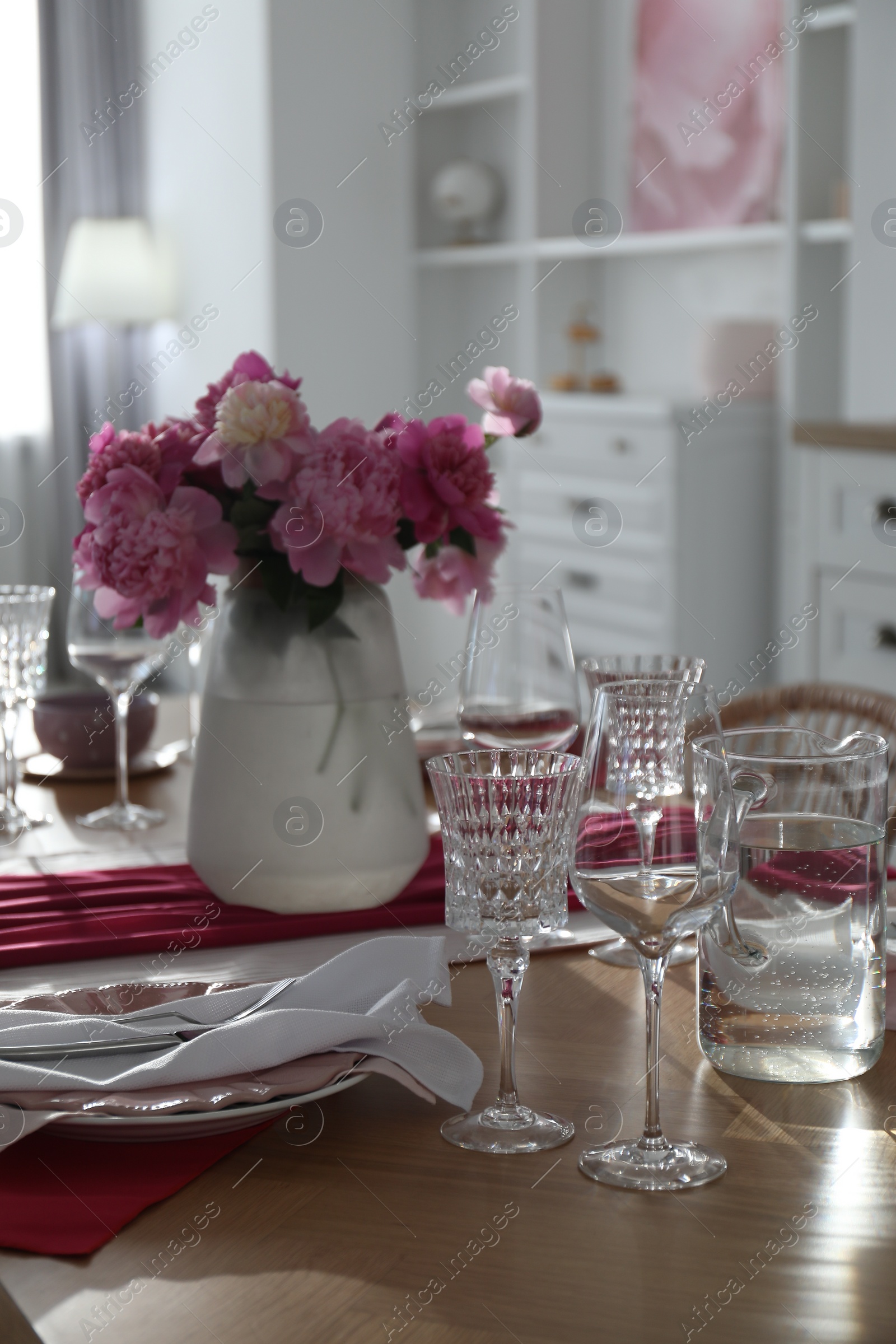 Photo of Beautiful table setting with pink peonies in dining room