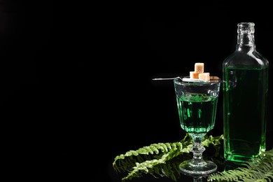 Photo of Absinthe, brown sugar, spoon and green leaves on mirror table, space for text. Alcoholic drink