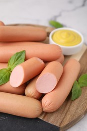 Photo of Delicious boiled sausages and basil on table, closeup