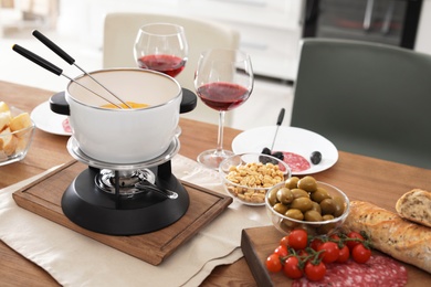 Fondue pot and different products on table indoors