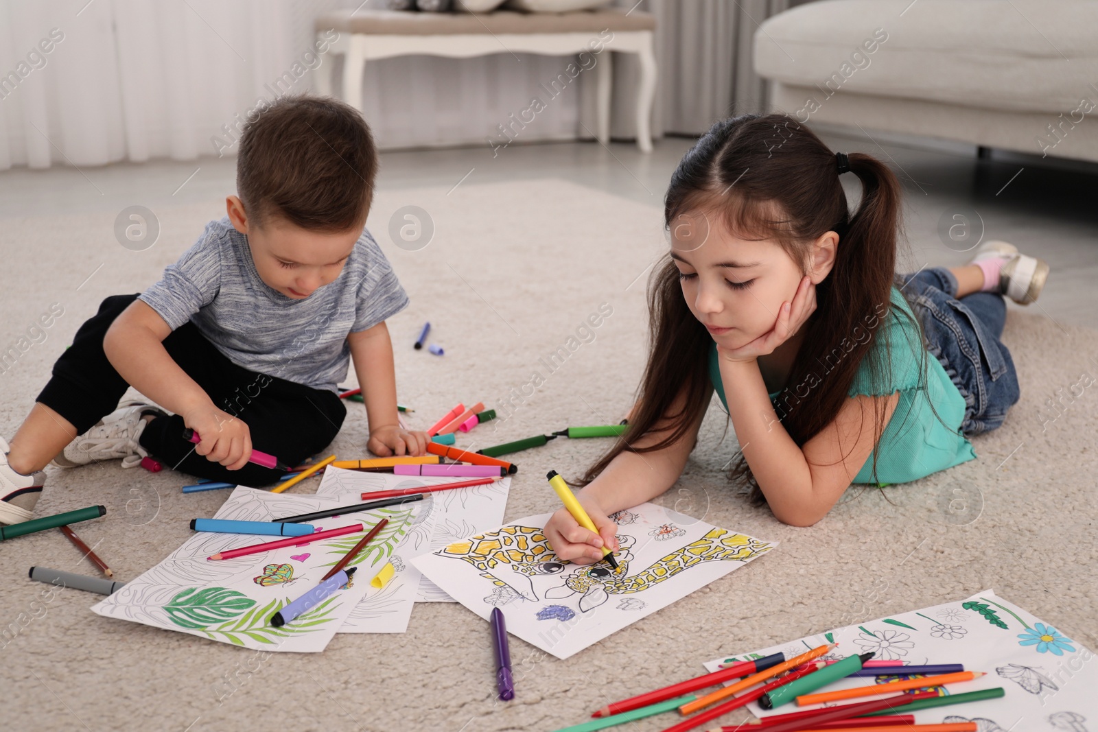 Photo of Cute children coloring drawings on floor at home