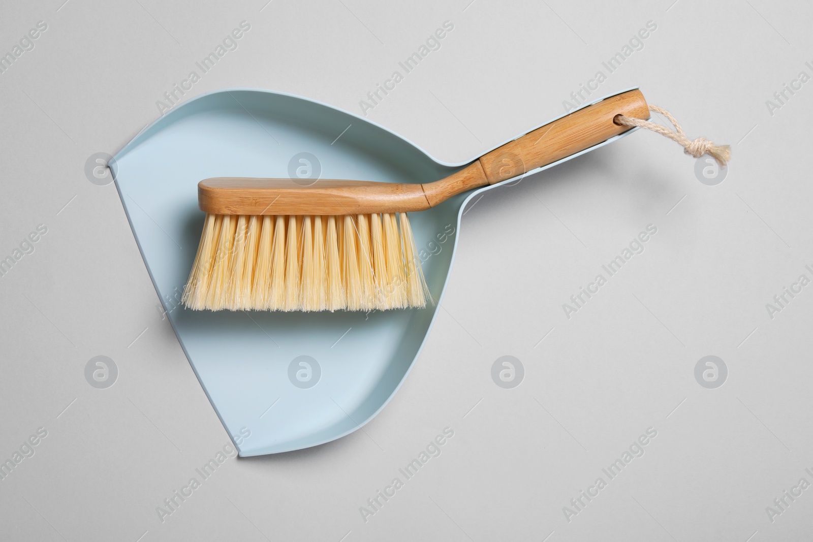 Photo of Cleaning brush and scoop on grey background, top view. Space for text