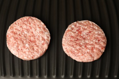 Fresh raw hamburger patties on grill pan, top view