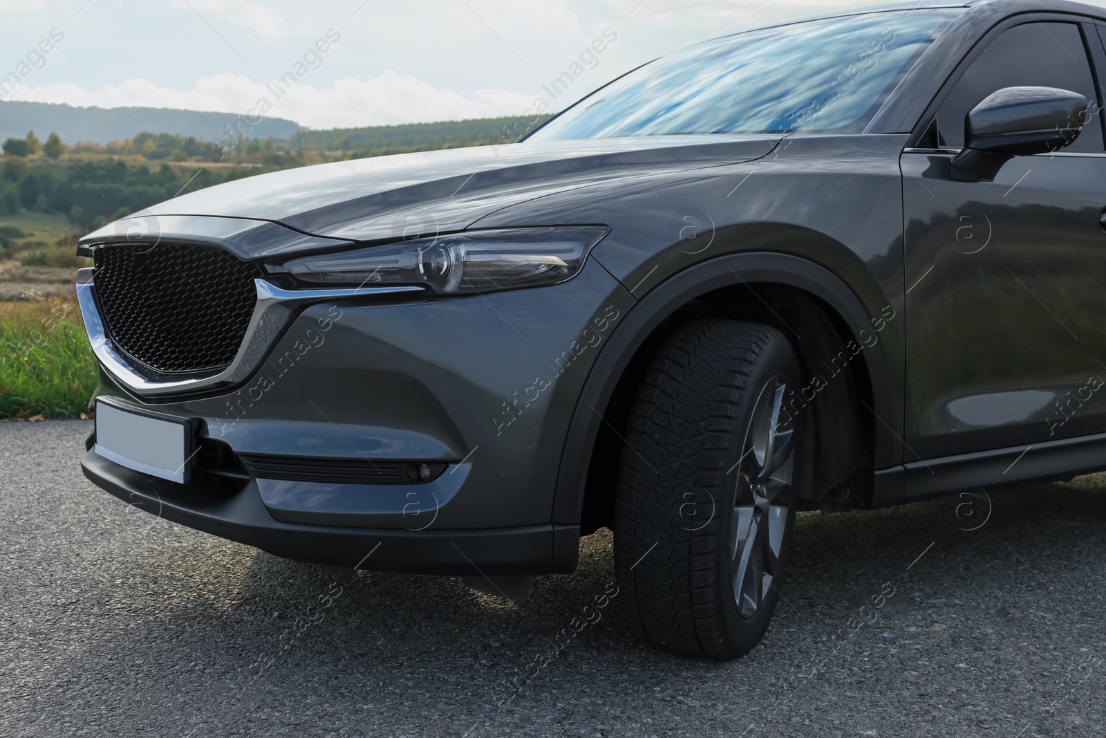 Photo of Black modern car parked on asphalt road, closeup