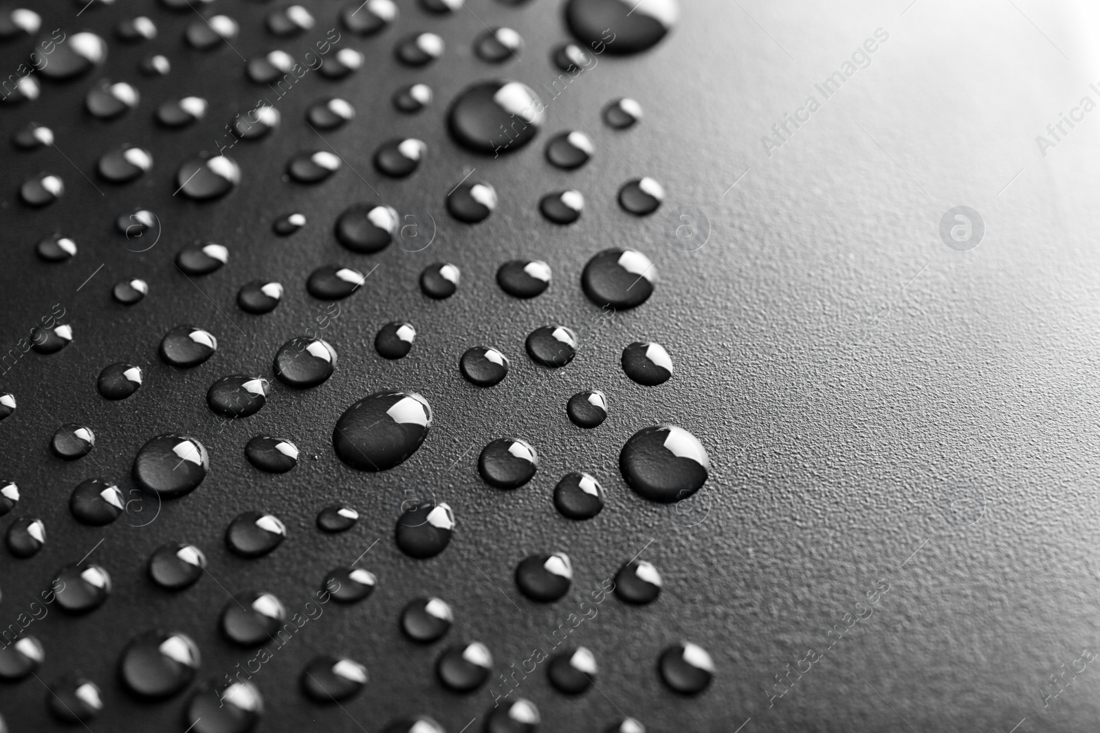 Photo of Many water drops on black background, closeup. Space for text