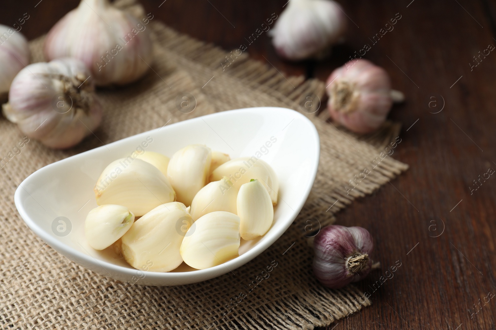 Photo of Fresh garlic cloves and bulbs on wooden table, closeup. Space for text