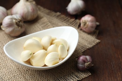 Fresh garlic cloves and bulbs on wooden table, closeup. Space for text