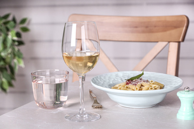 Photo of Delicious pasta with tomato sauce served on light marble table