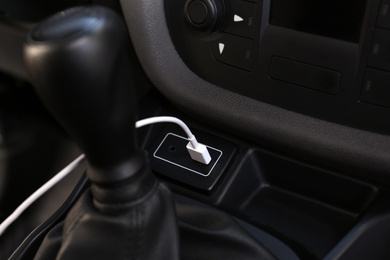 White USB charging cable plugged in inside modern car