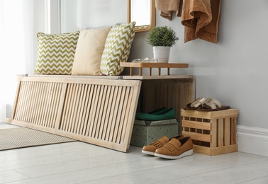 Stylish hallway interior with storage bench near light wall