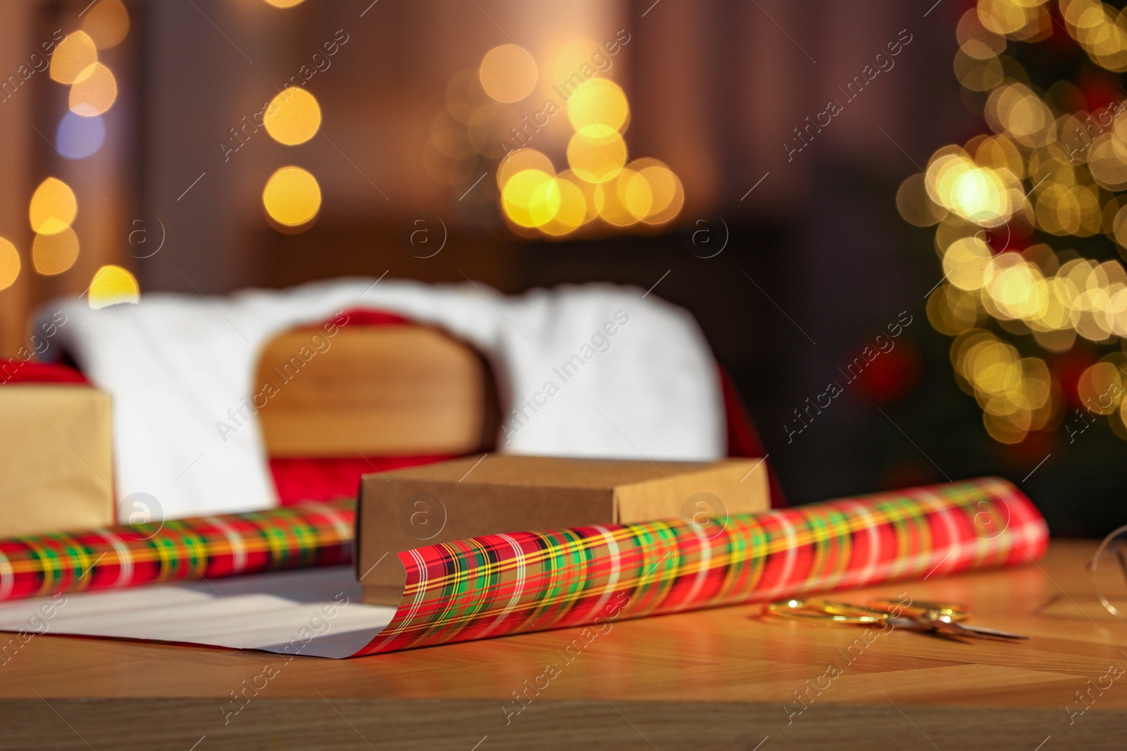 Photo of Santa's Claus workplace. Christmas gift and wrapping paper on table in room