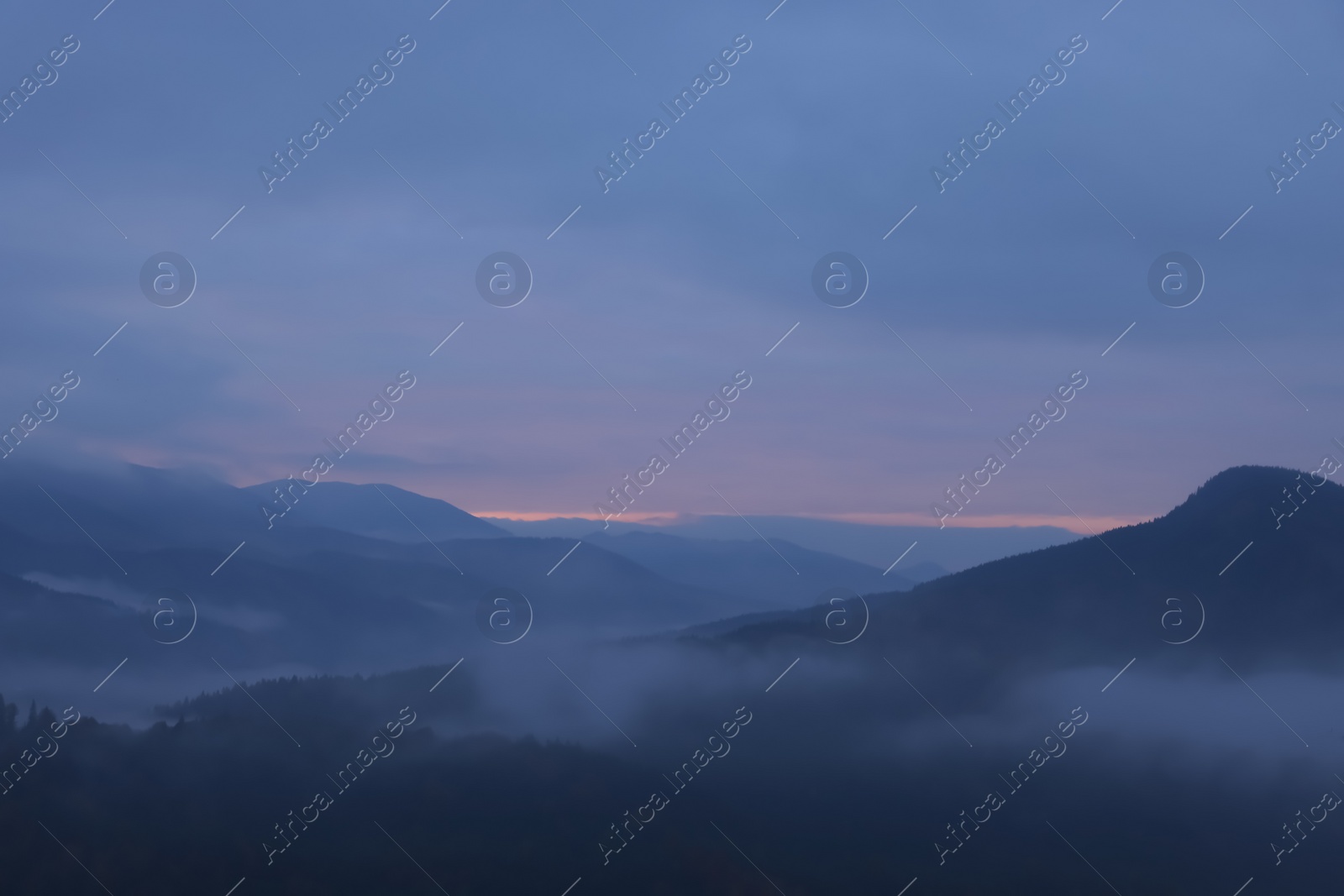 Photo of Beautiful view of mountains covered with fog during sunrise