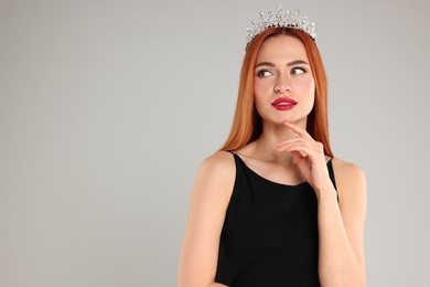 Photo of Beautiful young woman with tiara in dress on light grey background, space for text