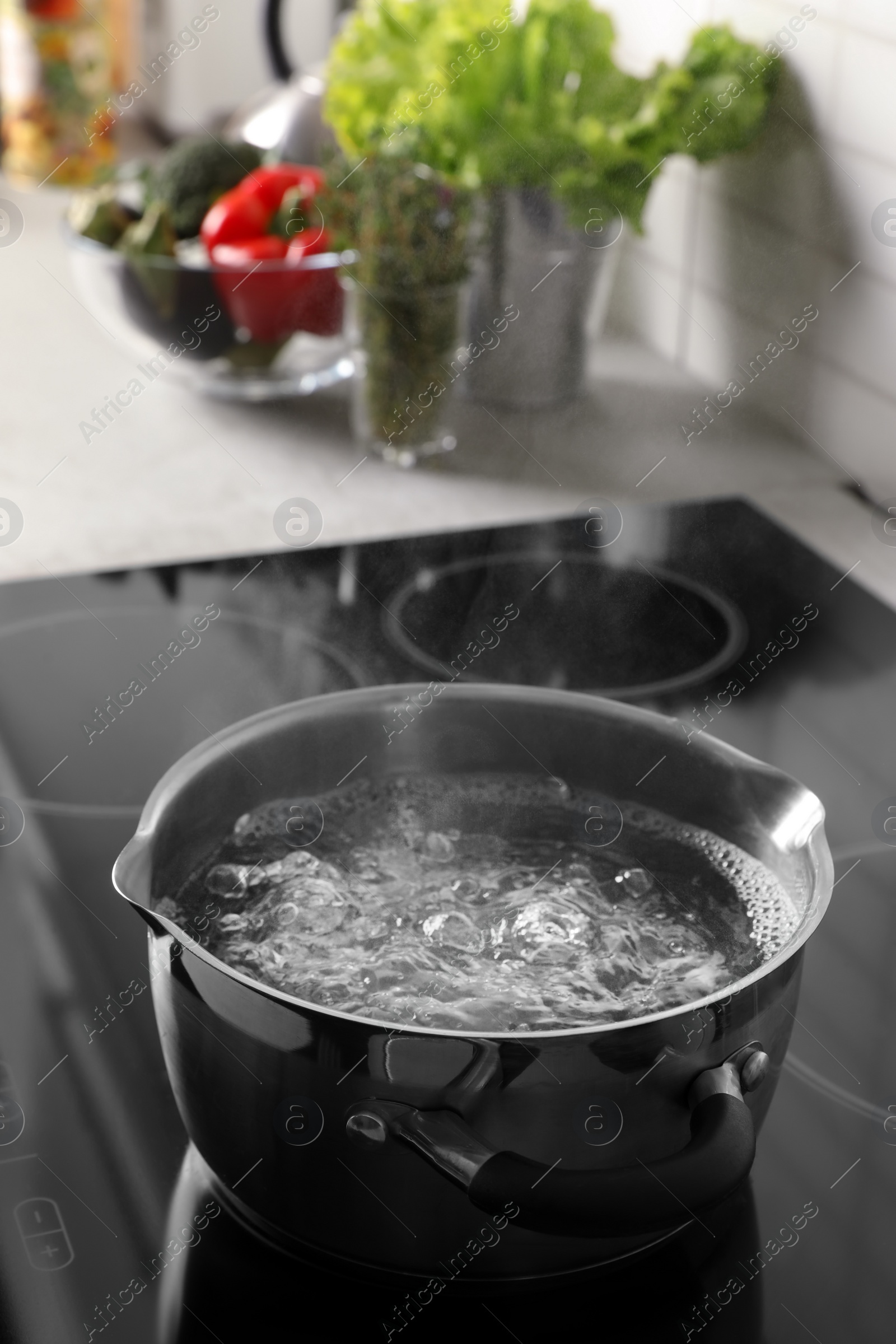 Photo of Pot with boiling water on electric stove in kitchen, space for text