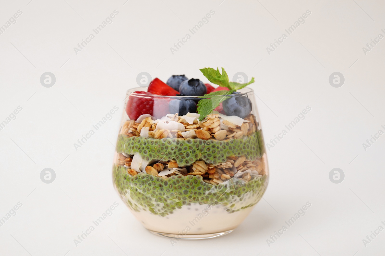 Photo of Tasty oatmeal with chia matcha pudding and berries on beige background. Healthy breakfast