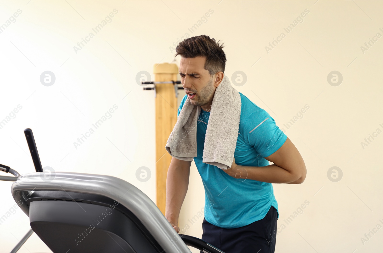Photo of Young man having heart attack on treadmill in gym