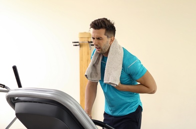 Photo of Young man having heart attack on treadmill in gym