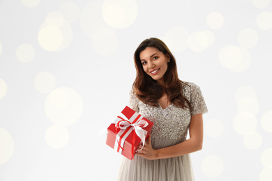 Beautiful woman with Christmas gift on white background