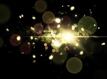 Image of Magic lights on black background, bokeh effect