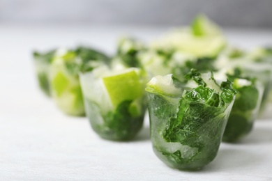 Photo of Lime and mint ice cubes on light table, closeup