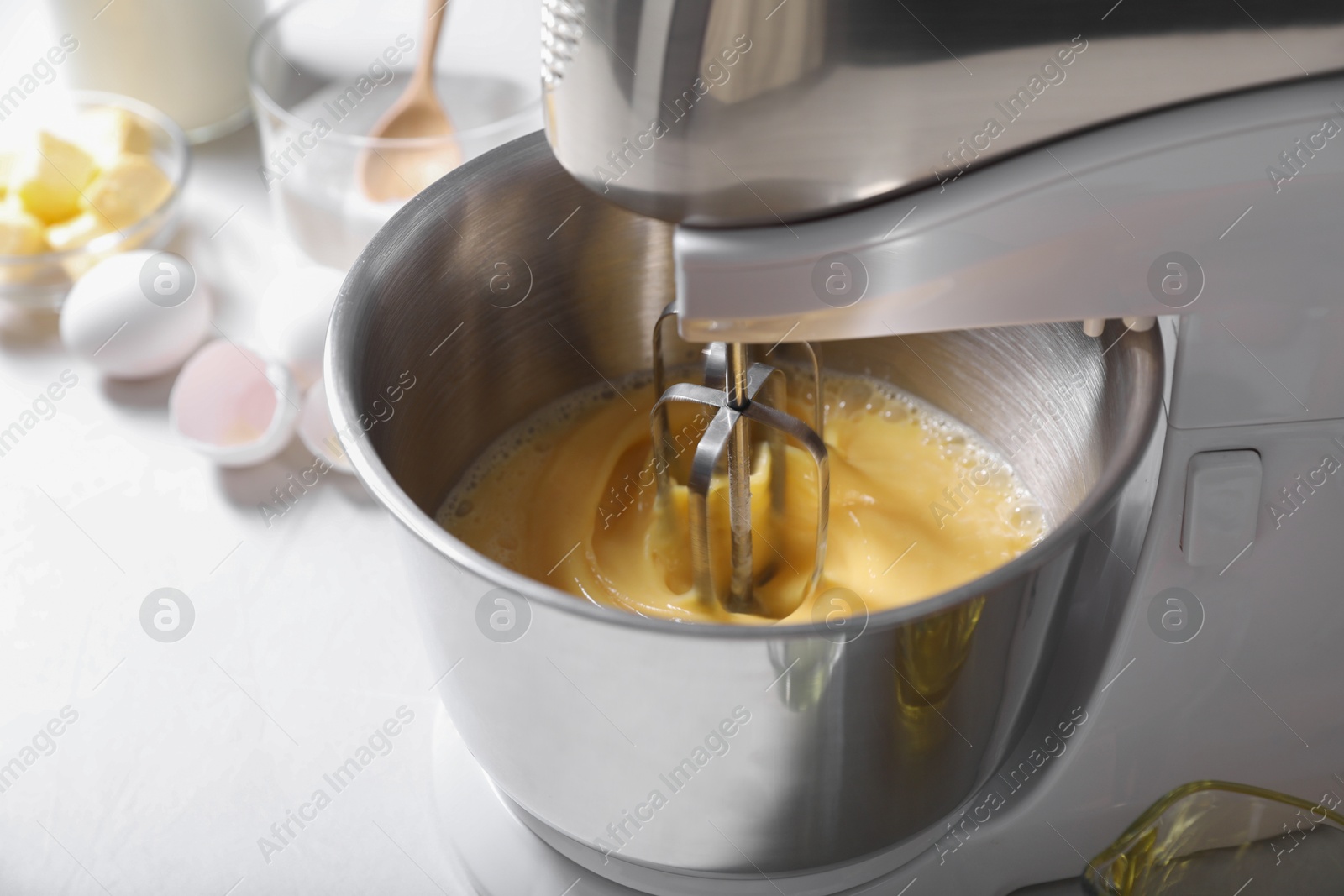 Photo of Making dough in bowl of stand mixer on white table, closeup