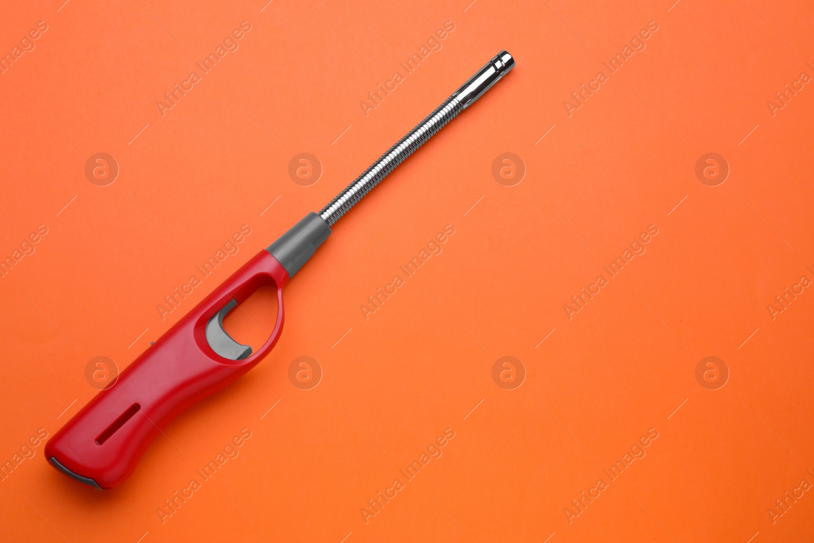 Photo of One gas lighter on orange background, top view. Space for text