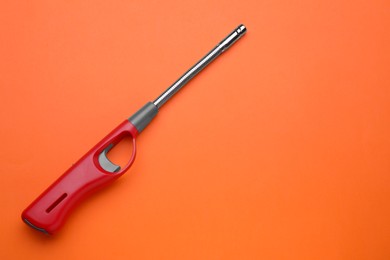 Photo of One gas lighter on orange background, top view. Space for text