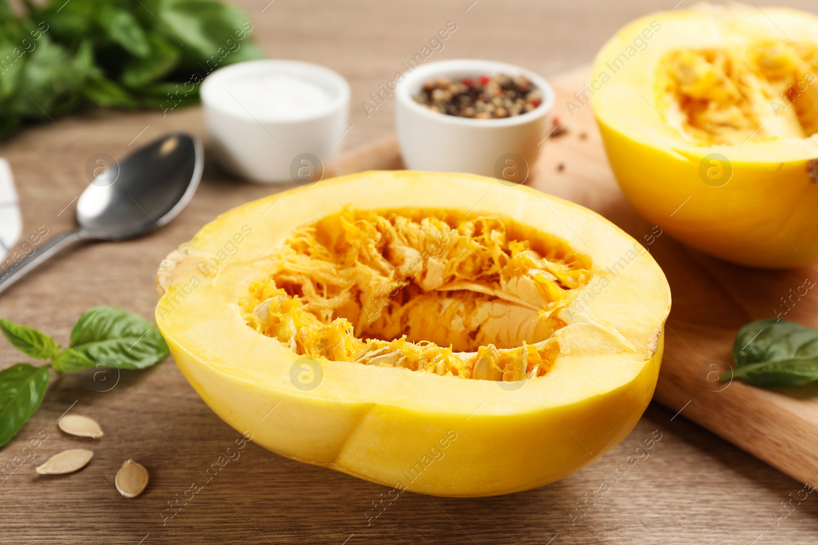 Photo of Half of fresh spaghetti squash on wooden table. Cooking vegetarian dish