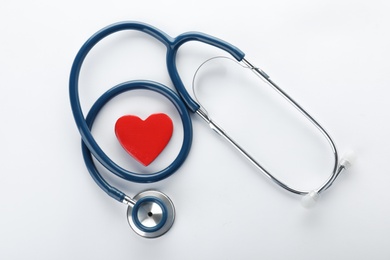 Photo of Stethoscope with red heart on white background, top view