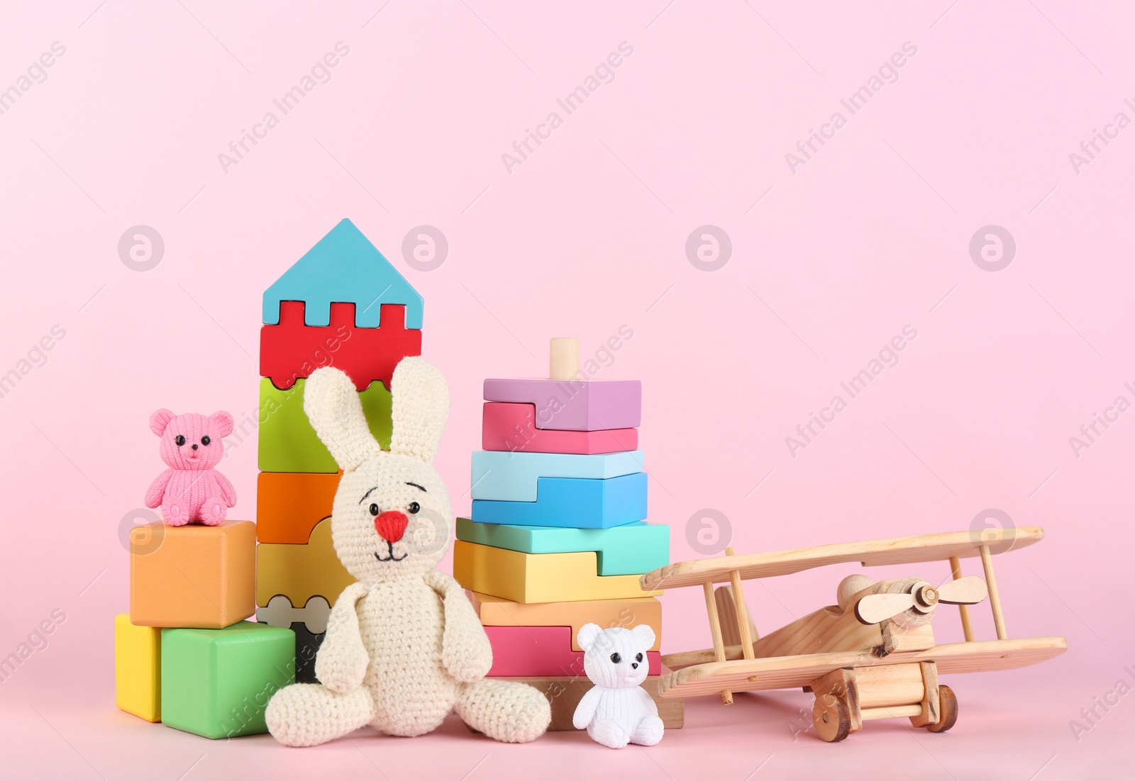 Photo of Set of different toys on pink background. Space for text