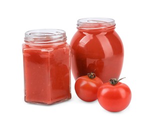 Photo of Organic ketchup in glass jars and fresh tomatoes isolated on white. Tomato sauce