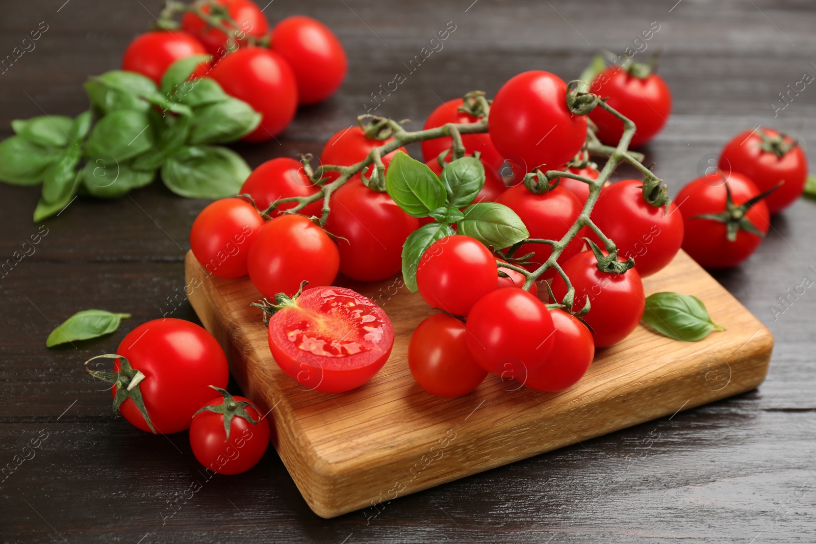 Photo of Fresh cherry tomatoes and basil on wooden table