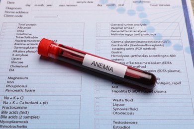 Test tube with blood sample and label Anemia on medical form