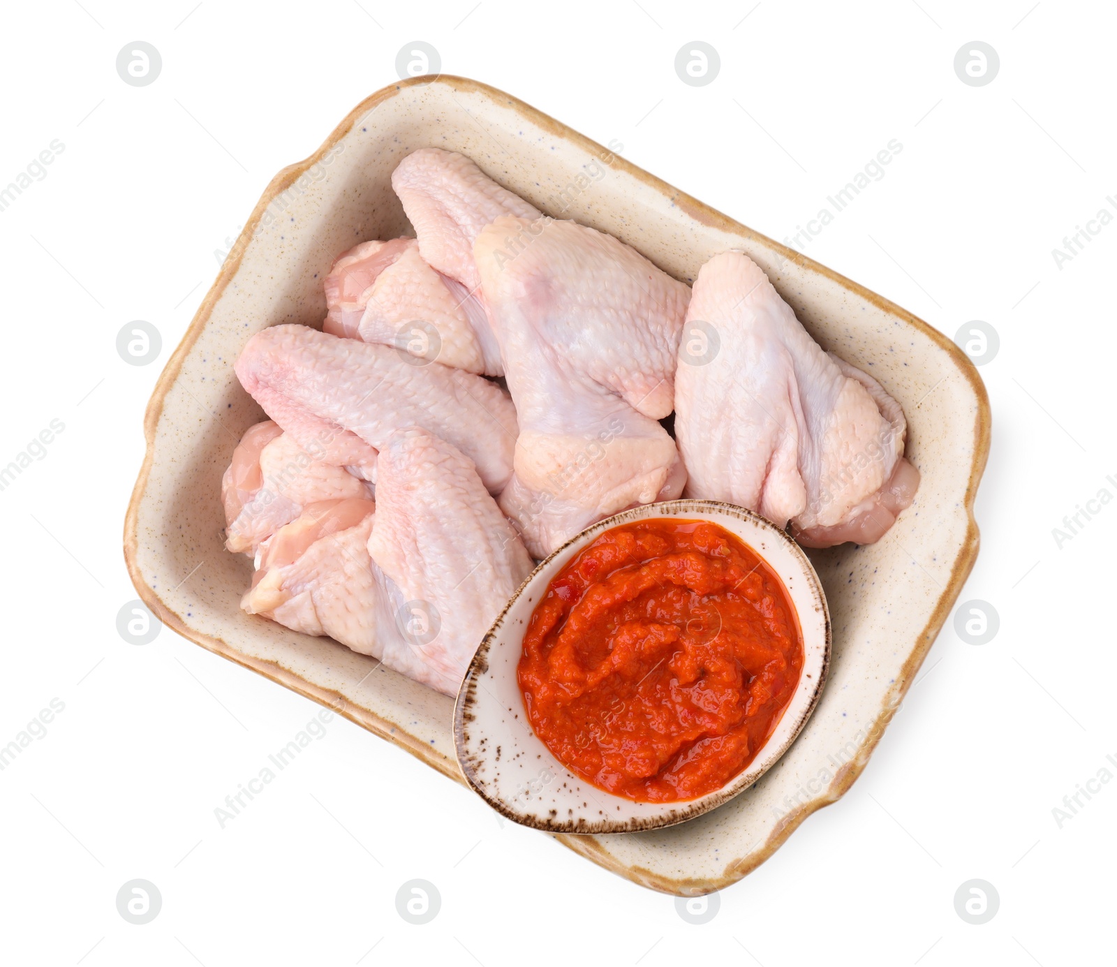 Photo of Fresh marinade and raw chicken in baking dish isolated on white, top view