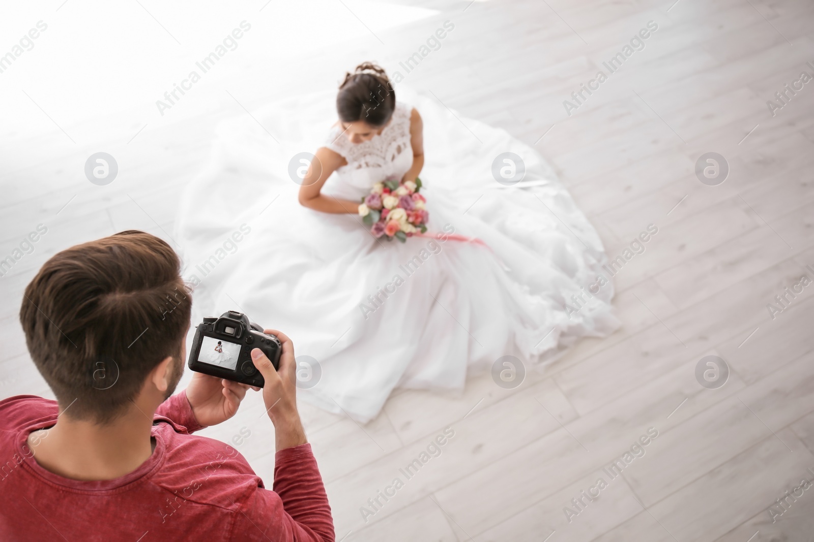 Photo of Professional photographer taking photo of beautiful bride in studio