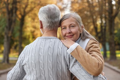 Affectionate senior couple dancing together in autumn park