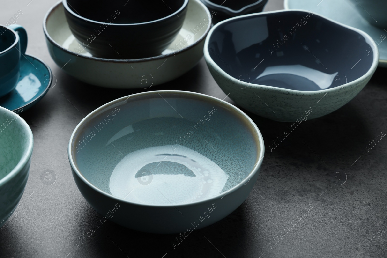 Photo of Set of stylish empty bowls on grey table