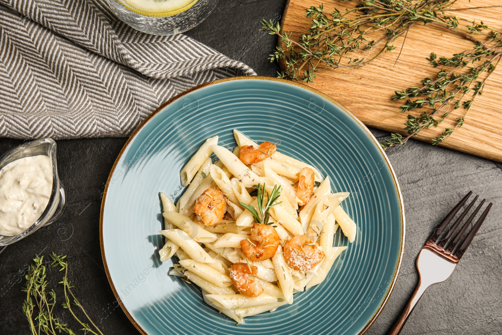 Photo of Delicious pasta with shrimps served on black table, flat lay