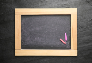 Photo of Empty blackboard with chalk on slate background, top view. Space for text