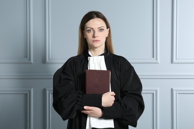 Portrait of judge with book near grey wall