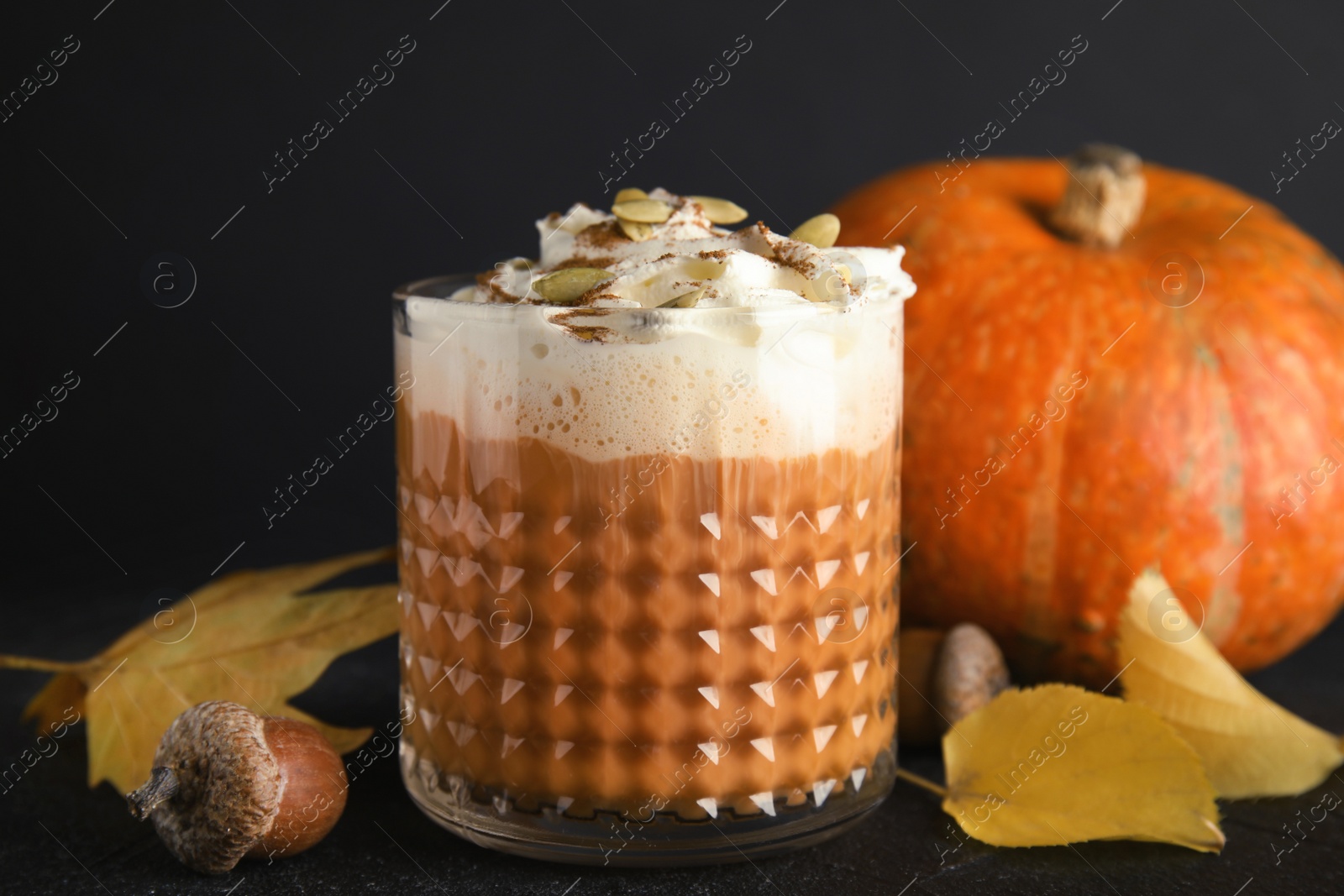 Photo of Composition with pumpkin spice latte on dark background