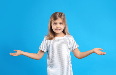 Photo of Emotional little girl on light blue background