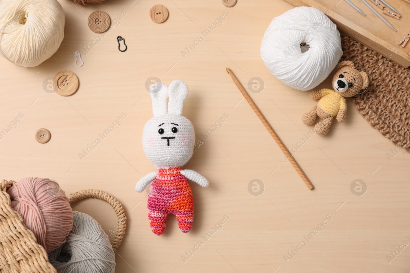 Photo of Flat lay composition with threads and crocheted toys on wooden table. Engaging hobby