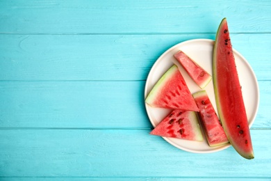 Photo of Yummy cut watermelon on light blue wooden table, top view. Space for text