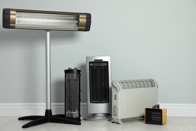 Photo of Different electric heaters near light grey wall indoors. Space for text