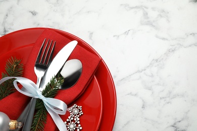 Festive table setting with beautiful dishware and Christmas decor on white marble background, top view. Space for text