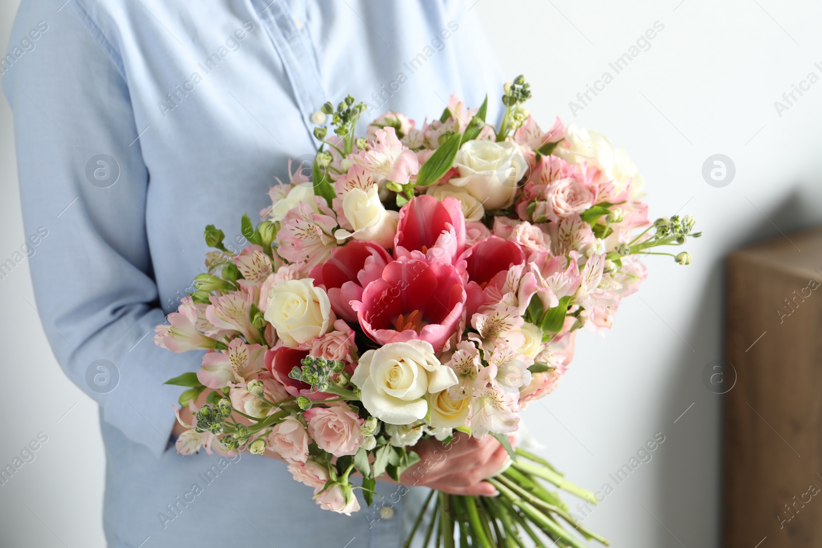 Photo of Woman with beautiful bouquet of fresh flowers indoors, closeup