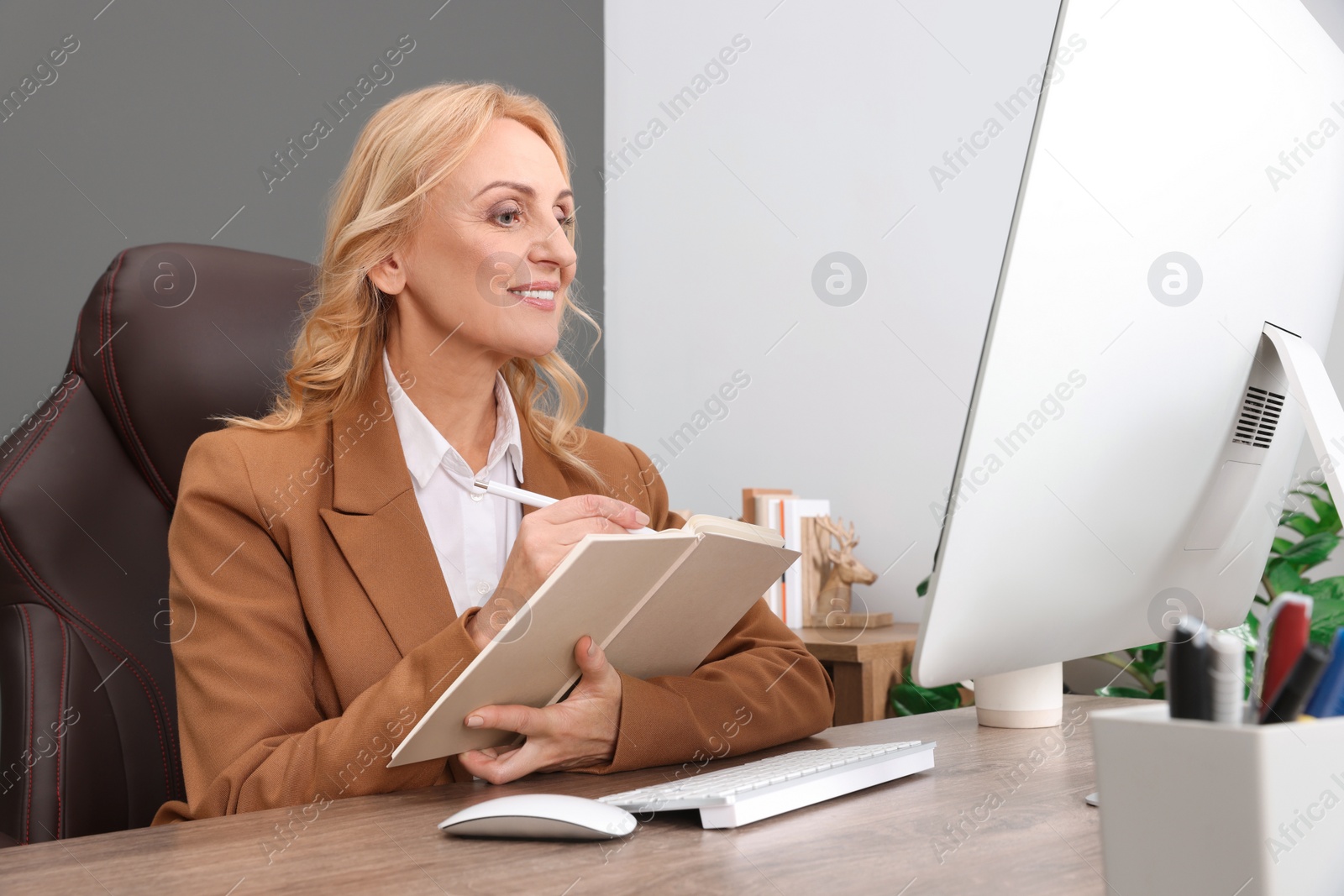 Photo of Lady boss working near computer at desk in office. Successful businesswoman