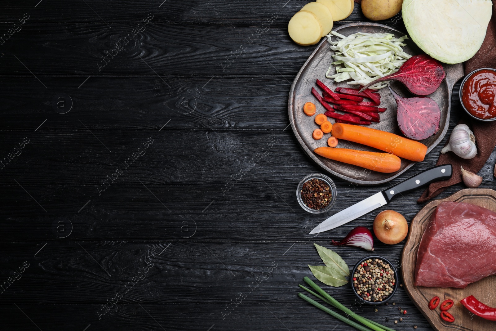 Photo of Fresh borscht ingredients on black wooden table, flat lay. Space for text